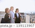 朝の通勤風景・屋外の歩道橋で前向きに微笑む3人の若手女性ビジネスパーソン・スーツ姿の新入社員 139113907
