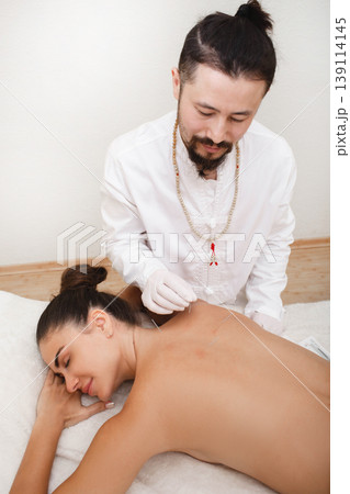 Reflexologist doing an acupuncture procedure. Stress relief with acupuncture. Traditional chinese medicine 139114145