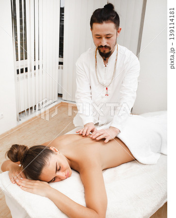 Doctor asian race doing energetic body massage. Woman getting reiki therapy. Alternative medicine 139114181