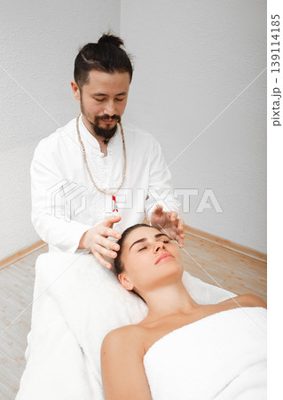 Chiropractor doing energetic head massage. Massage helps transform negative energy into positive energy. Alternative medicine 139114185