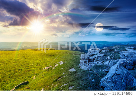 mountainous landscape during summer solstice. day meet night. sun and moon over boulders and rock formations surrounded grassy hills. picture of an untouched highland. equality and shift template mountainous landscape during summer solstice. day meet night. sun and moon over boulders and rock formations surrounded grassy hills. picture of an untouched highland. equality and shift template 139114696
