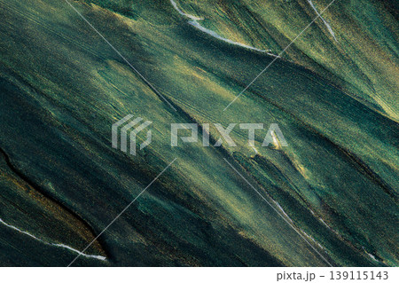 Abstract oil paint with glitter creating diagonal flowing green and golden patterns Abstract oil paint with glitter creating diagonal flowing green and golden patterns 139115143