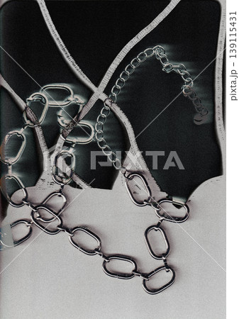 Abstract dark aesthetic of chunky silver chains over distorted background. Moody industrial grunge, noir fashion jewelry, metallic textures, edgy Y2K style for contemporary street culture designs. Abstract dark aesthetic of chunky silver chains over distorted background. Moody industrial grunge, noir fashion jewelry, metallic textures, edgy Y2K style for contemporary street culture designs. 139115431