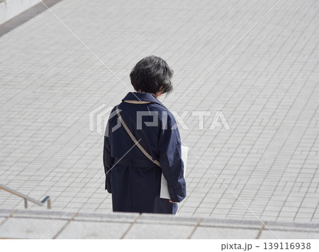 春の朝の名古屋駅前広場に散歩するシニア女性の姿 139116938