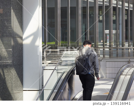 名古屋駅前の商業施設のエスカレーターに登る若い男性サラリーマンの姿 名古屋駅前の商業施設のエスカレーターに登る若い男性サラリーマンの姿 139116941