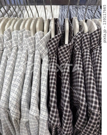 Stacked checkered shirts in store display showcasing various plaid patterns, suitable for background Stacked checkered shirts in store display showcasing various plaid patterns, suitable for background 139117665