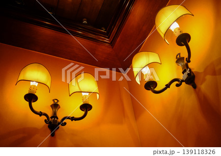Close-up of the lamp hanging on the wall indoors. Interior design, indoor decoration.  139118326