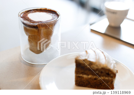 Chilled milk coffee in skull shape cup on table by the window. Chilled milk coffee in skull shape cup on table by the window. 139118969
