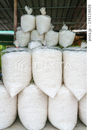 White sea salt grains packed in clear plastic bags stacked for sale at a local outdoor market. Traditional food seasoning and grocery trade in Southeast Asia White sea salt grains packed in clear plastic bags stacked for sale at a local outdoor market. Traditional food seasoning and grocery trade in Southeast Asia 139119026