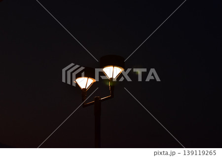 Close-up of the street light at night. City street lamp post in the street at night. Cityscape and lighting scene. Close-up of the street light at night. City street lamp post in the street at night. Cityscape and lighting scene. 139119265