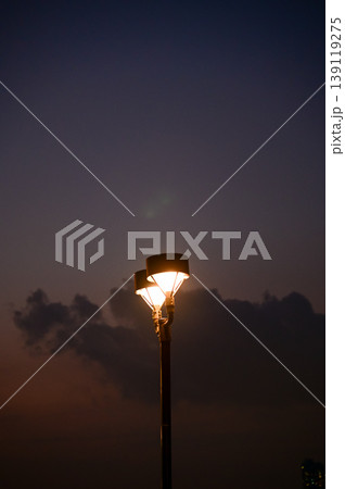 Close-up of the street light at night. City street lamp post in the street at night. Cityscape and lighting scene. Close-up of the street light at night. City street lamp post in the street at night. Cityscape and lighting scene. 139119275