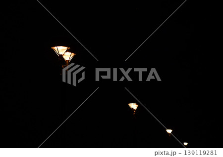 Close-up of the street light at night. City street lamp post in the street at night. Cityscape and lighting scene. Close-up of the street light at night. City street lamp post in the street at night. Cityscape and lighting scene. 139119281