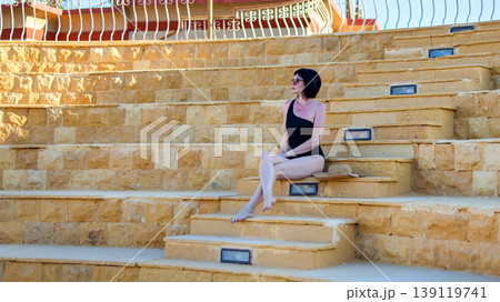 A woman in a bikini on the steps of the old amphitheater A woman in a bikini on the steps of the old amphitheater 139119741