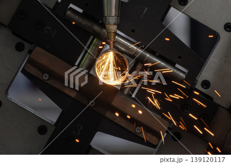 High-precision fiber laser cutting machine processing a stainless steel pipe in a modern industrial plant. 139120117