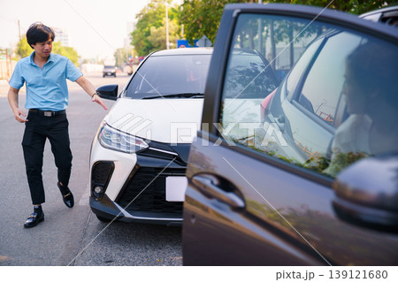 Two drivers inspecting car accident and discussing damage Two drivers inspecting car accident and discussing damage 139121680