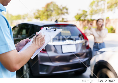 Agent filling car insurance claim form with stressed female driver Agent filling car insurance claim form with stressed female driver 139121687
