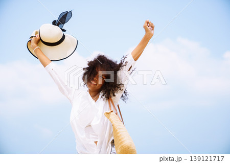 Happy black woman with arms up on summer vacation beach trip 139121717