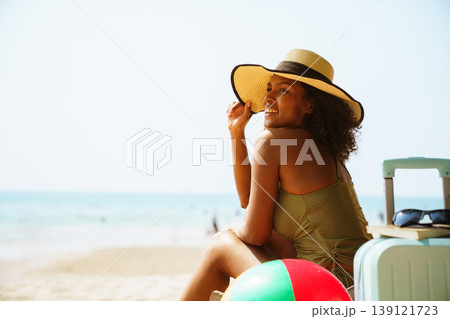 Happy black woman relaxing in deck chair on sunny beach vacation Happy black woman relaxing in deck chair on sunny beach vacation 139121723