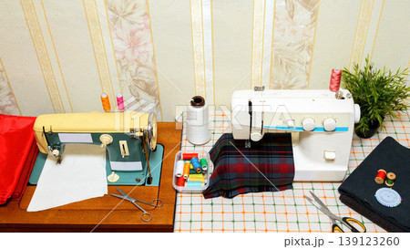 general view of the sewing workspace with two machines and fabric general view of the sewing workspace with two machines and fabric 139123260