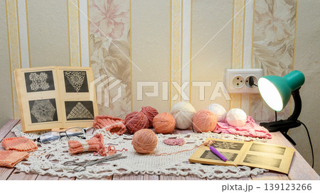 frontal view of a table with crochet and knitting supplies frontal view of a table with crochet and knitting supplies 139123266
