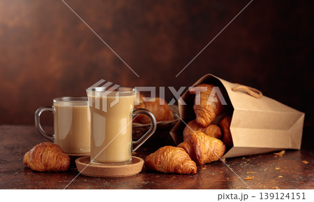 Coffee latte and croissants on a brown table. Coffee latte and croissants on a brown table. 139124151