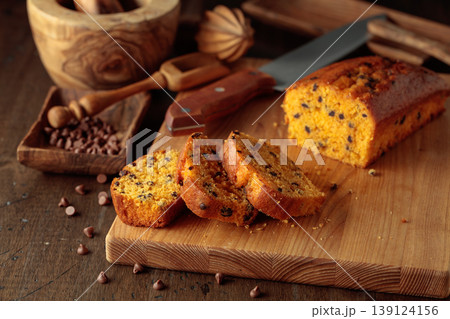 Cake with chocolate pieces on a kitchen table. 139124156