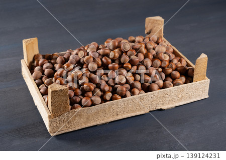 Pile of hazelnuts in a wooden crate. 139124231