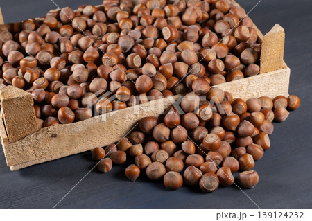 Pile of hazelnuts in a wooden crate. 139124232
