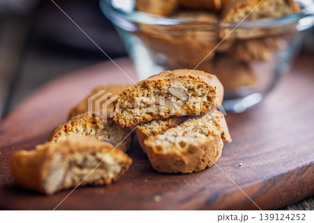 Crunchy Almond Biscotti Cookies cantuccini on Wooden Board With Glass Bowl Rustic Italian Snack 139124252