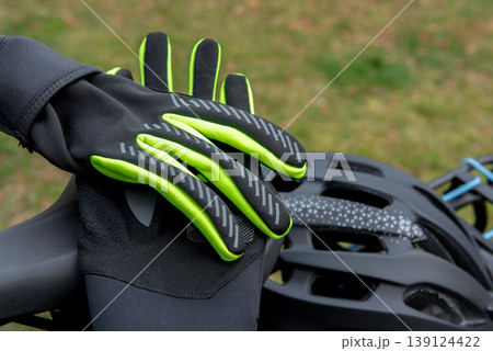 Cycling gloves placed on the bike seat and helmet on the rear rack. 139124422