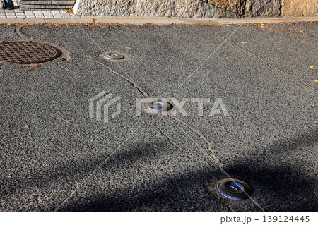 Retractable hydraulic bollard point ( Car barrier ) In unused mode on street pavement Retractable hydraulic bollard point ( Car barrier ) In unused mode on street pavement 139124445