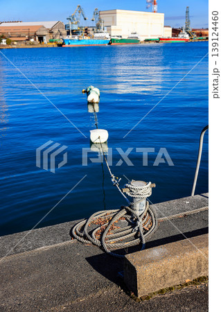 Mooring line on rusty pier referred to a post on a ship or quay. Mooring line on rusty pier referred to a post on a ship or quay. 139124460