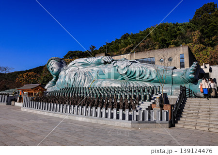 The world's largest reclining bronze Buddha statue is at Nanzo-in Temple in Fukuoka Prefecture, Japan. In front of the Buddha image is a prayer cylinder etched with prayer. 139124476