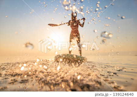 Silhouette of girl walking on sup board by the sea during summer vacation 139124640