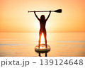 Young woman walking on stand up paddle sup boards by the sea during summer vacation 139124648