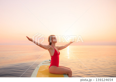 Young woman walking on sup board by the sea during summer vacation 139124654