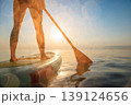 Women's legs on sup board by the sea during summer vacation 139124656