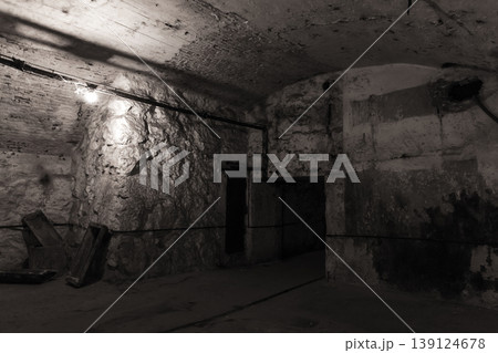 An abandoned underground cellar featuring rough stone and concrete walls 139124678