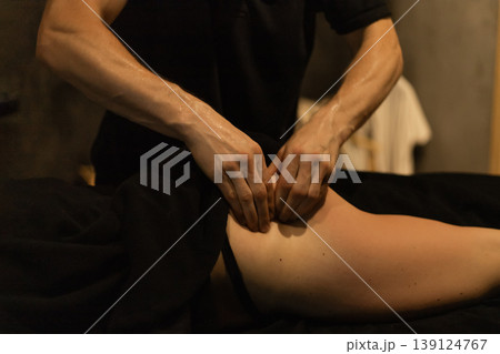 Professional therapist providing a therapeutic leg massage in a serene spa setting Professional therapist providing a therapeutic leg massage in a serene spa setting 139124767