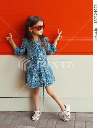 Beautiful little girl child wearing blue dress on city street 139124996