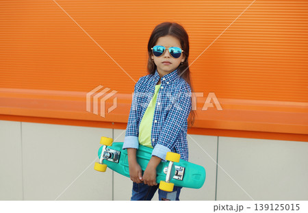 Stylish girl child with skateboard posing in the city Stylish girl child with skateboard posing in the city 139125015