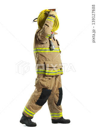 Firefighter in full protective suit carrying fire hose 139127688