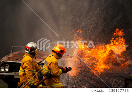 Firefighters putting out intense car fire with water spray Firefighters putting out intense car fire with water spray 139127758