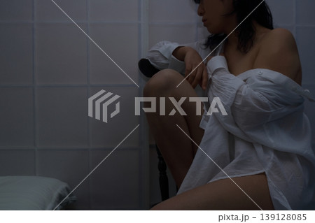 白いシャツを着て椅子に座る女性 白いシャツを着て椅子に座る女性 139128085