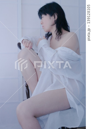 白いシャツを着て椅子に座る女性 白いシャツを着て椅子に座る女性 139128105