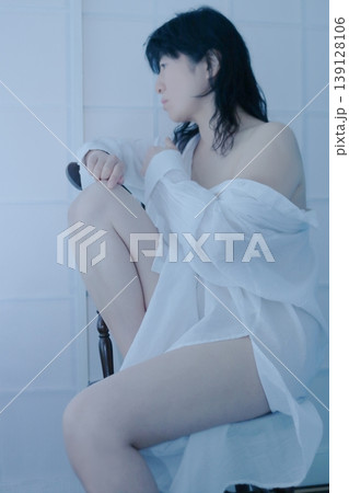 白いシャツを着て椅子に座る女性 白いシャツを着て椅子に座る女性 139128106