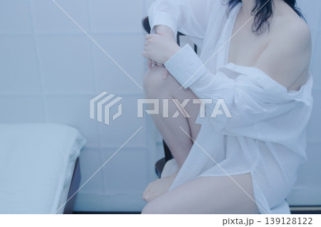 白いシャツを着て椅子に座る女性 139128122