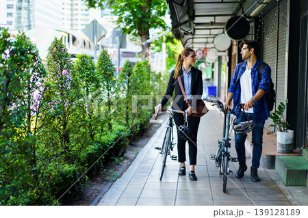 Business people with bicycles walking in urban environment. Business people with bicycles walking in urban environment. 139128189