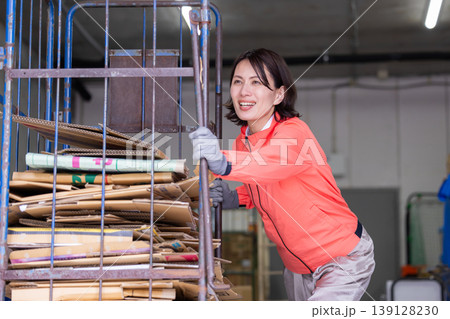 倉庫　ダンボールカートを運ぶ女性 139128230