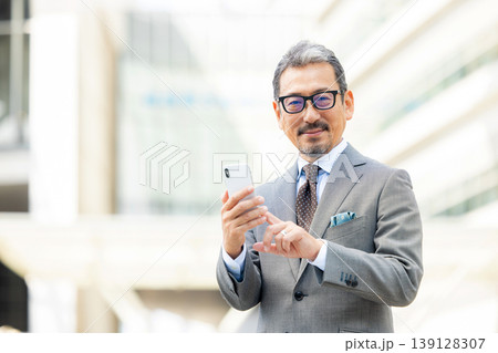 スマートフォンを操作するシニア男性 スマートフォンを操作するシニア男性 139128307